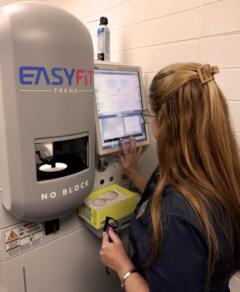 Optician operating a lens cutting machine with a touchscreen elios optical